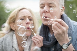 Older couple blowing bubbles in park